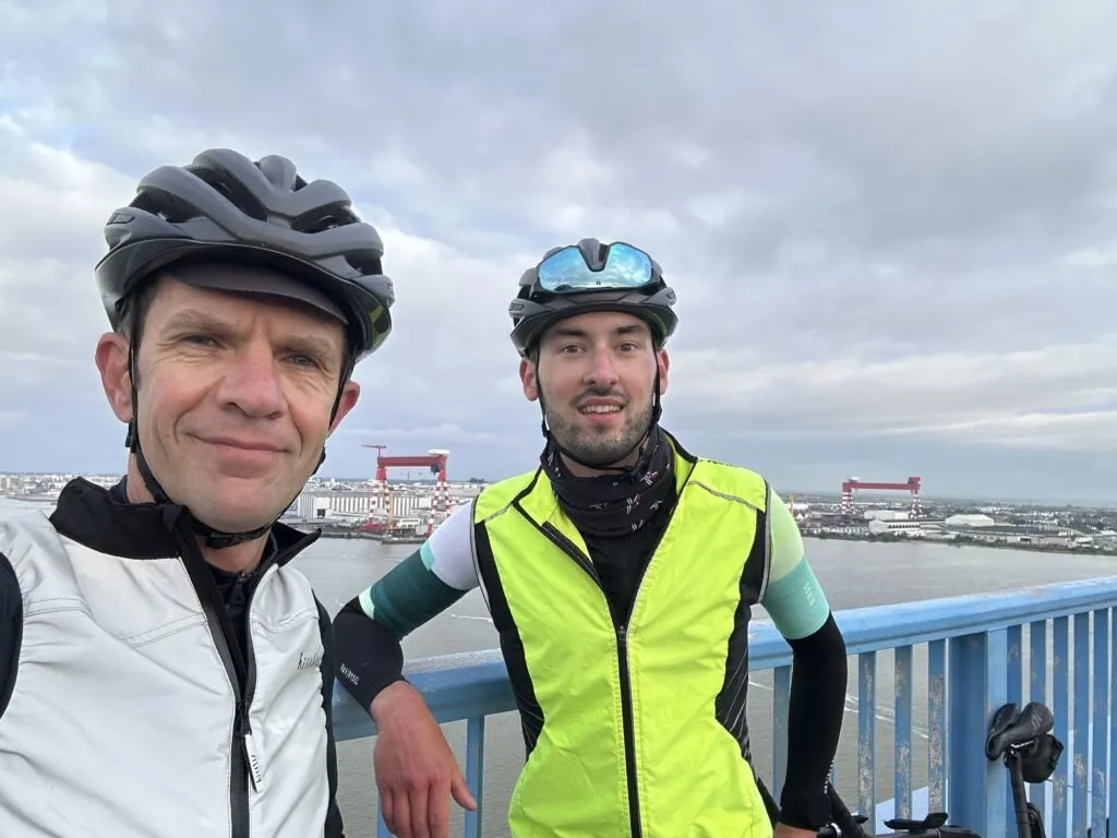 Cycliste prenend la pose sur le pont de Saint-Nazaire avec le chantier naval en arrière plan