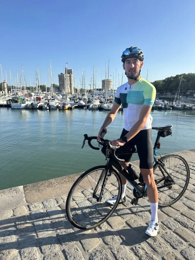 Cycliste prenend la pose devant la Tour Saint-Nicolas de La Rochelle