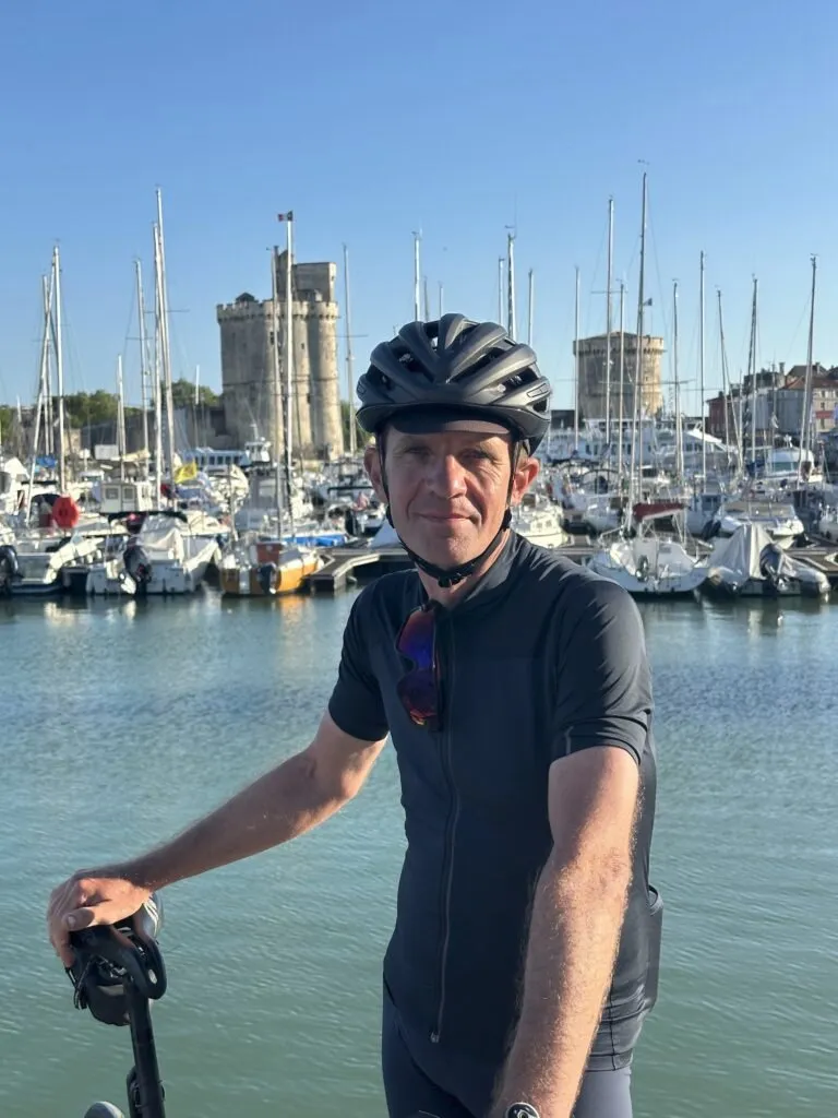 Cycliste prenend la pose devant la Tour Saint-Nicolas de La Rochelle